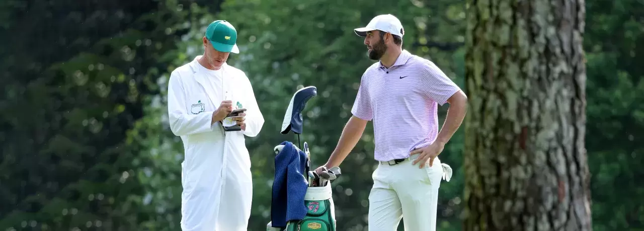 Scottie Scheffler of the United States and his caddie, Ted Scott, look on from the 11th hole during a practice round prior to the 2024 Masters Tournament at Augusta National Golf Club