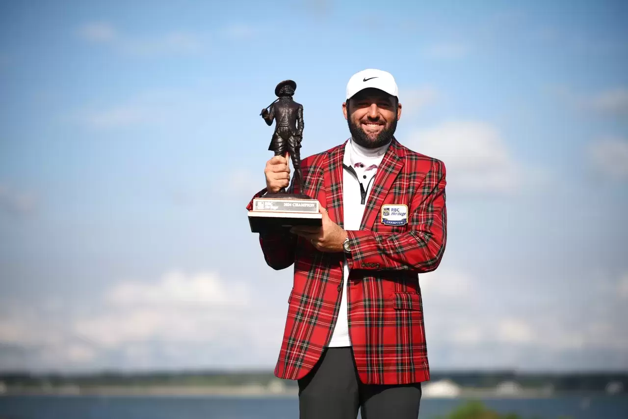 Scottie Scheffler of the United States celebrates with the trophy and the tartan jacket after winning during the continuation of the final round of the RBC Heritage at Harbour Town Golf Links