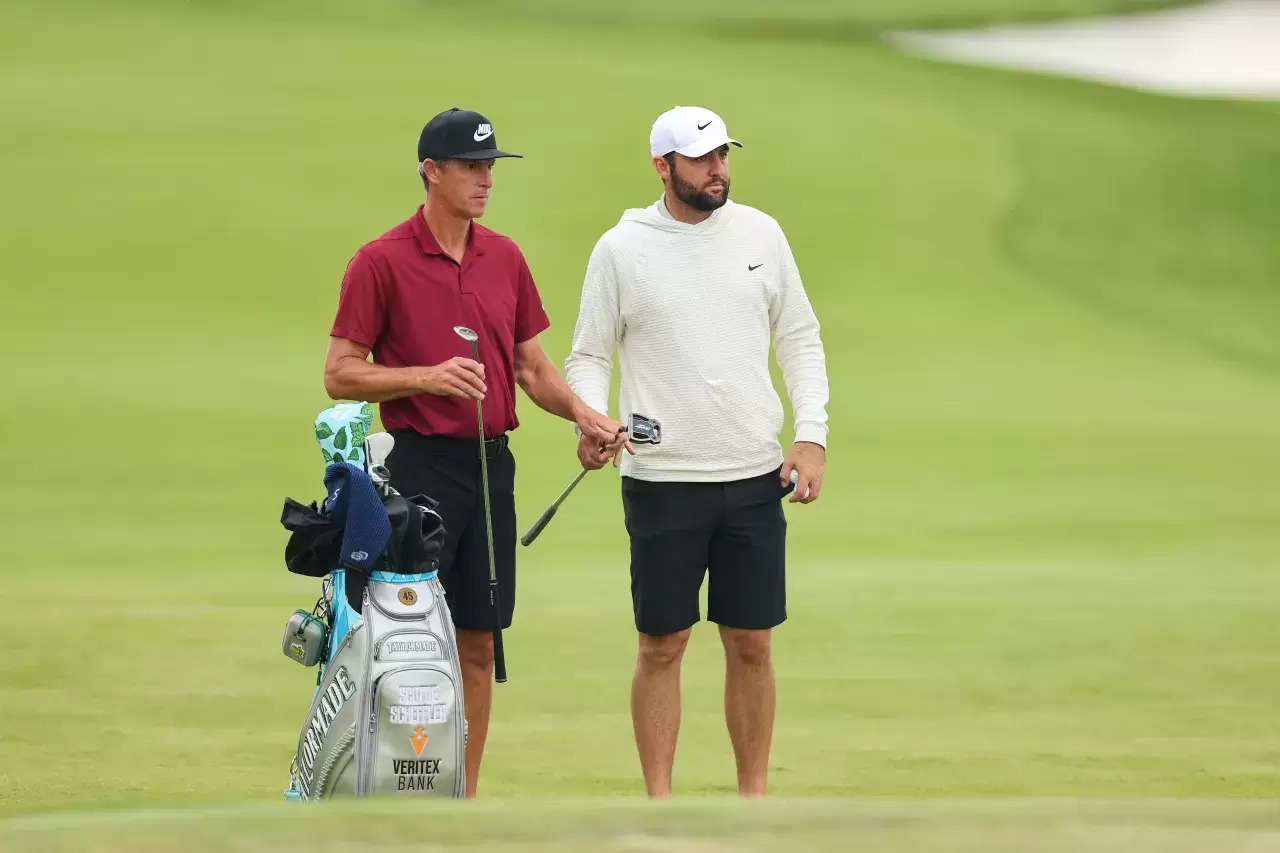 Scottie Scheffler of the United States and caddie Ted Scott walk across the 10th green during a practice round prior to the 2024 PGA Championship at Valhalla Golf Club on May