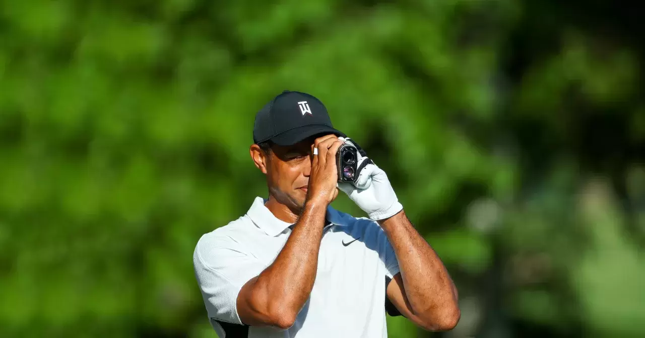 Tiger Woods of the United States uses a rangefinder to the start of the 2022 PGA Championship