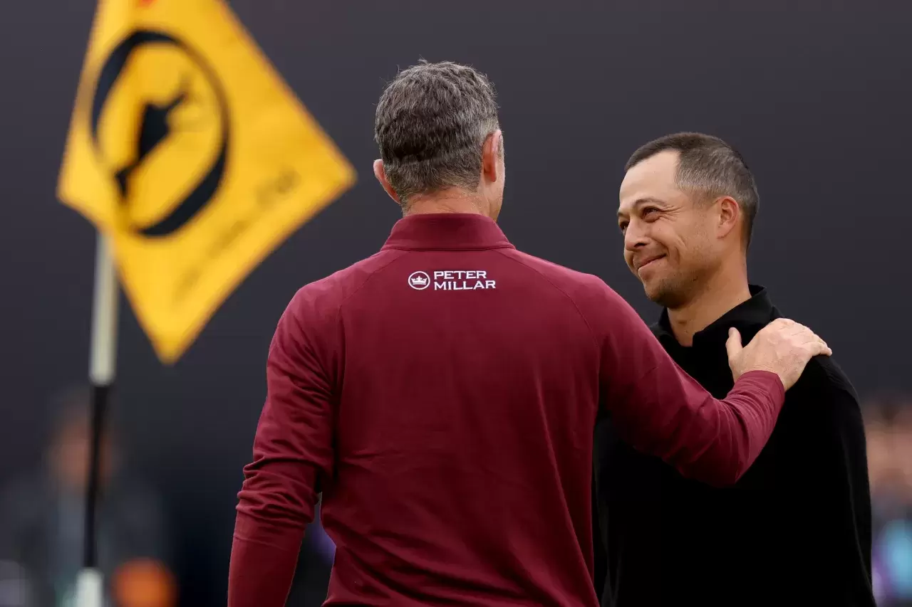 Xander Schauffele of the United States and Justin Rose of England embrace on the 18th green during day four of The 152nd Open championship at Royal Troon
