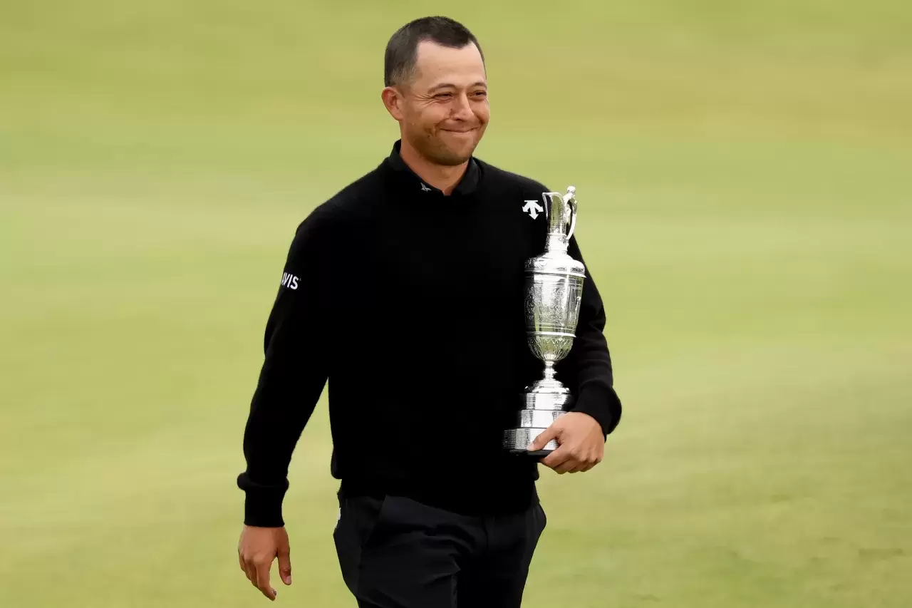 Xander Schauffele of the United States carries the Claret Jug on the 18th green in celebration of victory during day four of The 152nd Open championship at Royal Troon on July 21, 2024 in Troon, Scotland