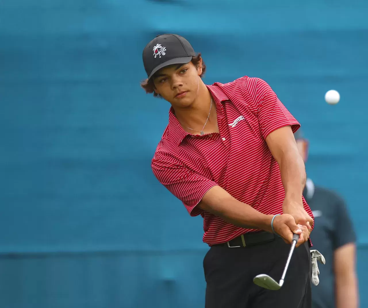 Charlie Woods of the United States chips on the 18th green.jpg