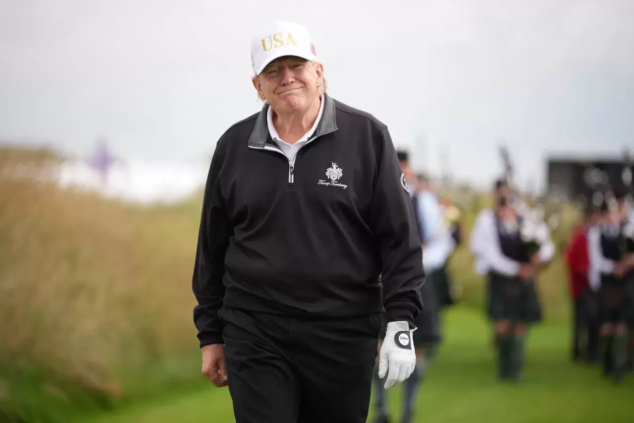 Donald Trump reacts as he walks on the course at the ribbon-cutting ceremony at a new 18-hole course at Trump International Golf Links