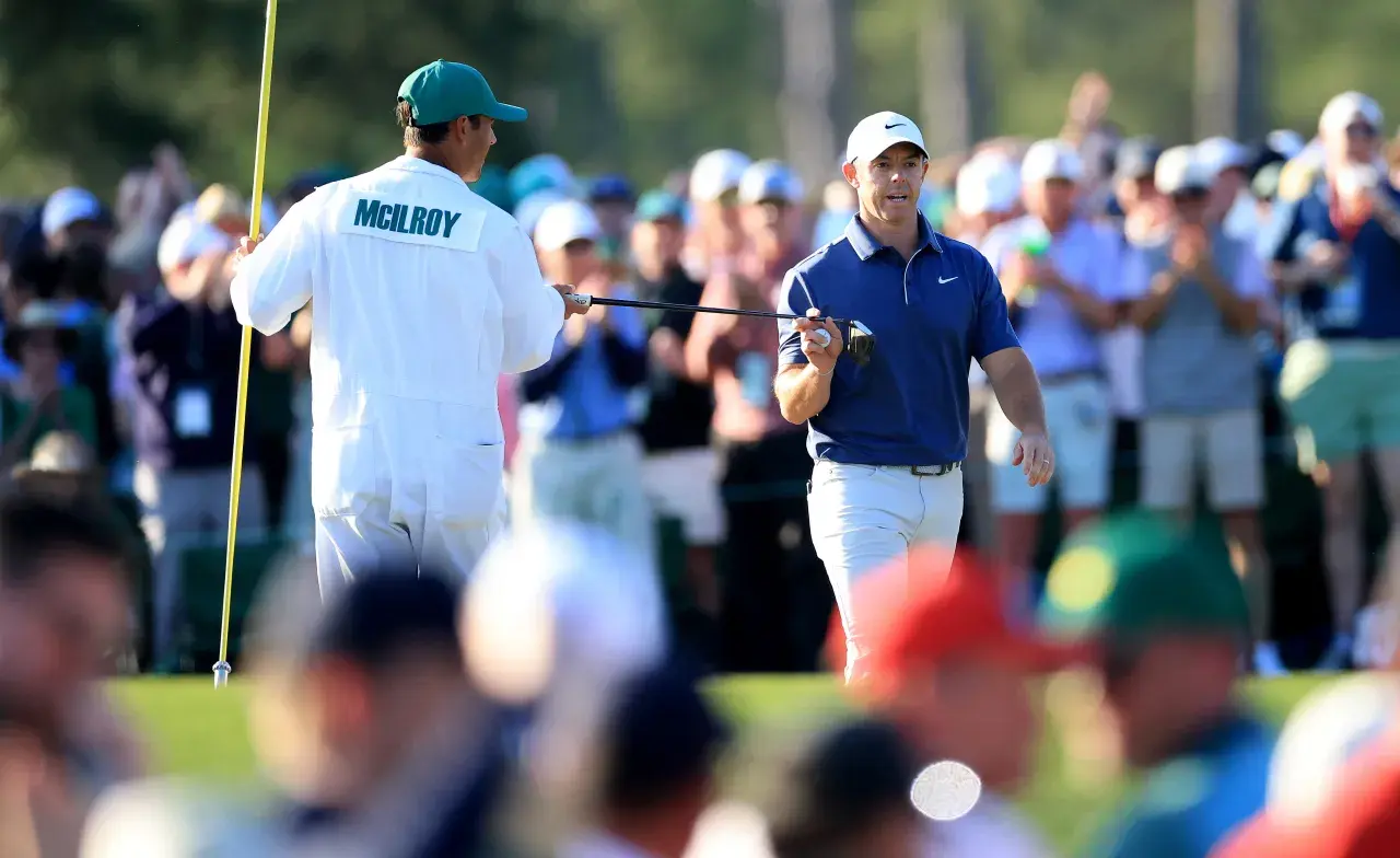 Rory McIlroy  Northern Ireland hands his putter to his caddie Harry Diamond after making a birdie on the 17th hole during the final round of the 2025 Masters GettyImages-2212821087.jpg