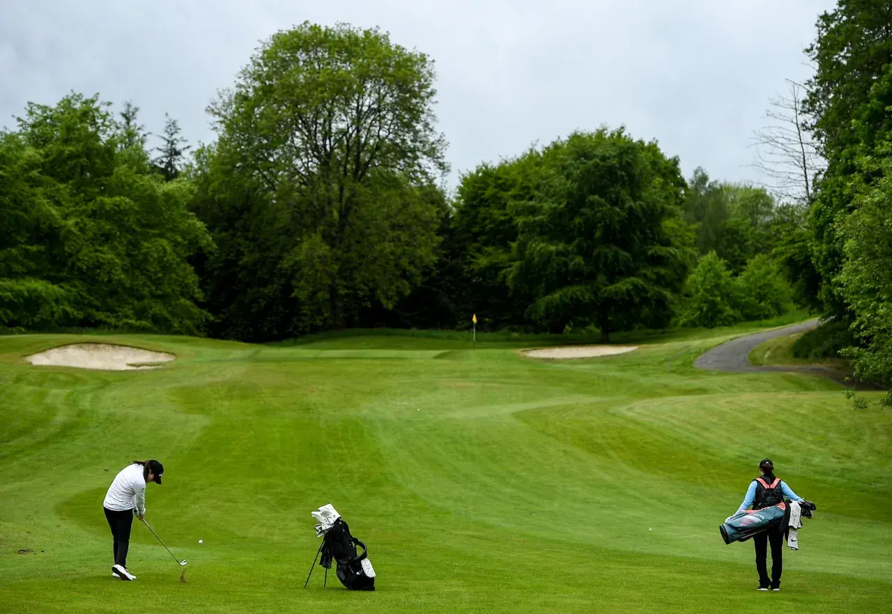 Cavan , Ireland - 18 May 2020; Irish professional golfer Leona Maguire hits her second shot on the 3rd hole, watched by her twin sister and former professional golfer Lisa Maguire during a round of golf at Slieve Russ.jpg