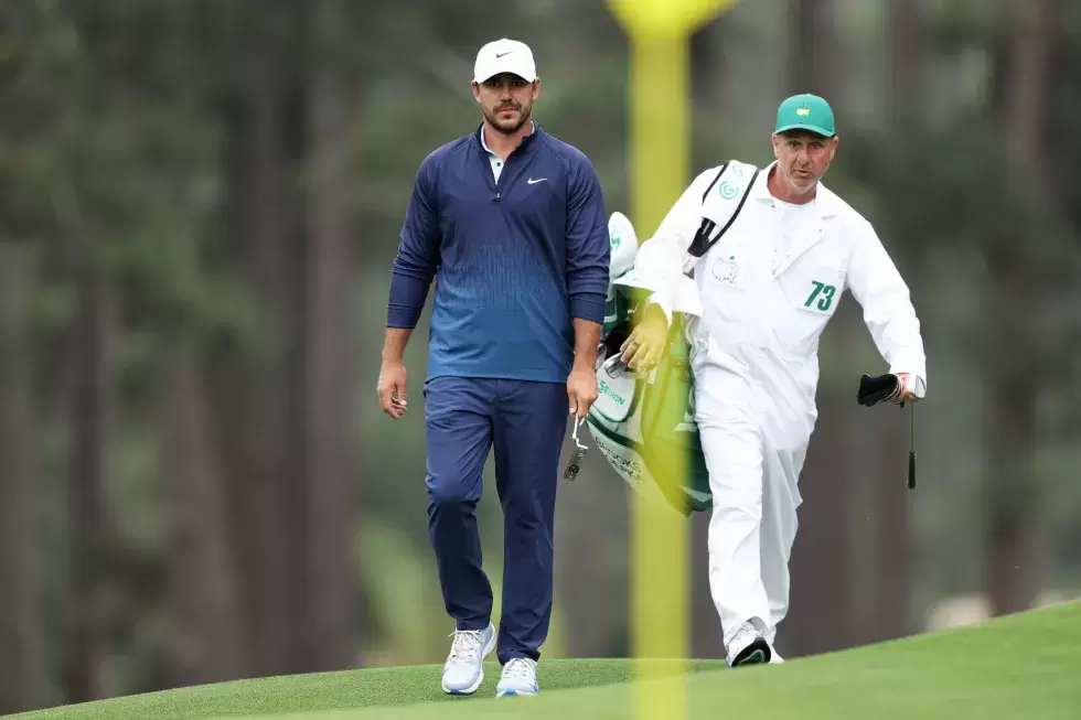 Brooks Koepka of the United States and caddie Ricky Elliott seen on the eighth green during a practice round prior to the 2024 Masters Tournament at Augusta National Golf Club 